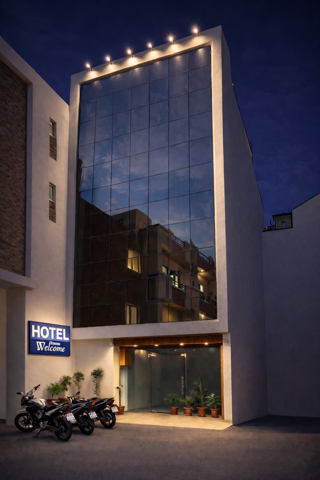 Hotel HR Premium Stay — modern glass facade lit at night in Vijay Nagar, Indore